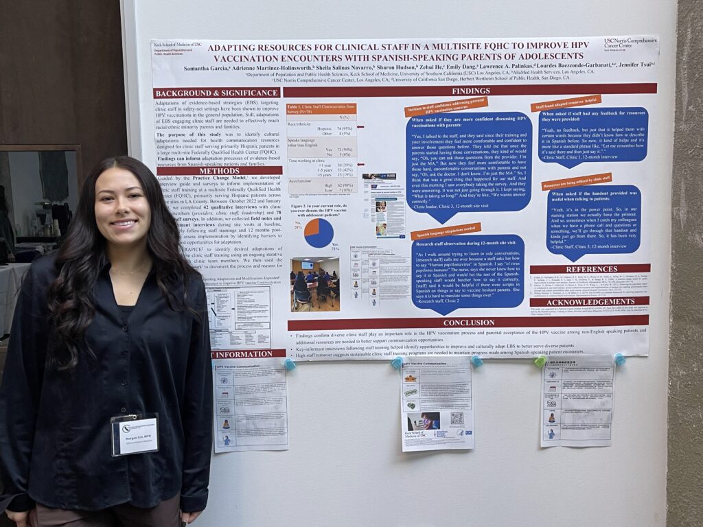 A woman standing next to a poster