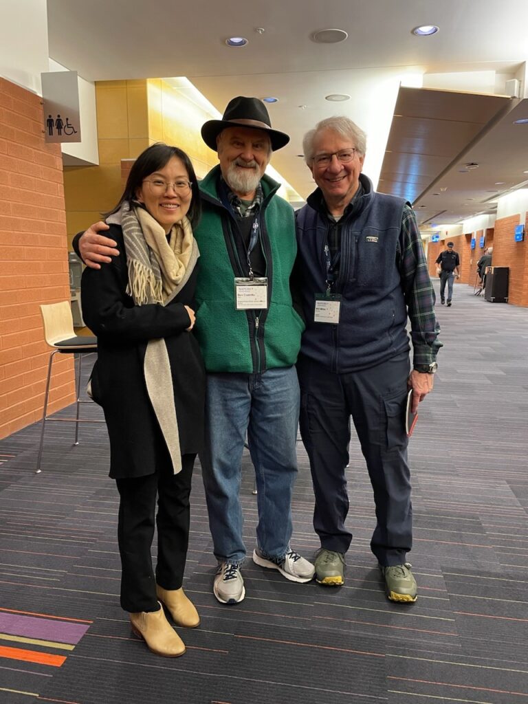 Photo of three individuals standing side by side and smiling